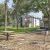 a brick courtyard with a picnic table and trees