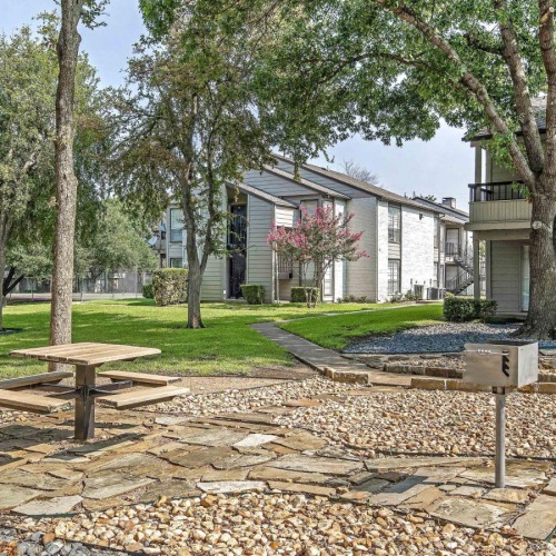 Settle into comfort at Hunters Glen a brick courtyard with a picnic table and trees